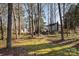 Expansive backyard featuring mature trees and landscaping surrounding the house and shed at 2542 Clearkirk Ct, Matthews, NC 28105