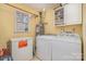 Well-lit laundry room with washer, dryer, freezer, water heater, and shelving at 2542 Clearkirk Ct, Matthews, NC 28105