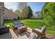 Relaxing backyard patio with wicker furniture and a lush lawn, perfect for outdoor enjoyment at 3216 Bridgewick Rd, Waxhaw, NC 28173