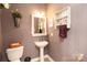Cozy half bath with pedestal sink, decorative shelf, and neutral wall color at 3216 Bridgewick Rd, Waxhaw, NC 28173