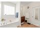Bright bathroom featuring a soaking tub with large window and a vanity at 3216 Bridgewick Rd, Waxhaw, NC 28173