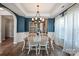 Charming dining room with wood table, white chairs, and elegant chandelier, perfect for Gathering meals at 3216 Bridgewick Rd, Waxhaw, NC 28173