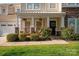 Welcoming front porch with chairs, hanging plants, stone pillar accents, and a black front door with floral wreath at 3216 Bridgewick Rd, Waxhaw, NC 28173