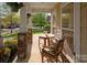 Cozy front porch featuring seating, stone pillars, and hanging flowers, offering a relaxing outdoor space at 3216 Bridgewick Rd, Waxhaw, NC 28173