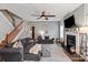 Inviting living room featuring a fireplace, ceiling fan, staircase, and cozy seating arrangements at 3216 Bridgewick Rd, Waxhaw, NC 28173