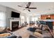 Open-concept living room with a cozy fireplace, ceiling fan, and view of the kitchen at 3216 Bridgewick Rd, Waxhaw, NC 28173