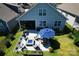 Aerial view of backyard with patio, fire pit, and outdoor seating with manicured lawn at 4023 Gozzi Dr, Iron Station, NC 28080