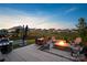 Outdoor patio area features a stone fire pit, dining table, grill, and lush green grass at 4023 Gozzi Dr, Iron Station, NC 28080