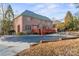 A brick home boasts an inviting outdoor area with a pool and a spacious red deck for entertaining at 4608 Snow Dr, Harrisburg, NC 28075