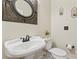 Elegant powder room featuring a pedestal sink, decorative mirror, and modern fixtures at 4608 Snow Dr, Harrisburg, NC 28075