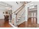 Elegant foyer with hardwood floors, staircase with white spindles, and views into dining area at 4608 Snow Dr, Harrisburg, NC 28075