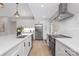 Modern kitchen featuring white cabinets, stainless steel appliances, quartz countertops, and wood-look flooring at 608 Kenlough Dr, Charlotte, NC 28209