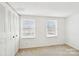 Bedroom showcasing neutral carpet, two windows, and a closet with folding doors at 7344 Pebblestone Dr # E, Charlotte, NC 28212