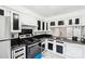 Well-lit kitchen with white cabinets, black countertops, and stainless steel appliances at 7344 Pebblestone Dr # E, Charlotte, NC 28212