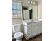 This bathroom features a white vanity with framed mirror, toilet, and vinyl floor at 7702 Brisbane Ct, Charlotte, NC 28215