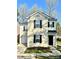 Charming two-story home featuring light siding, black shutters, and an attached one car garage at 7702 Brisbane Ct, Charlotte, NC 28215