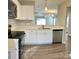 Modern kitchen featuring stainless steel appliances, white cabinets, and quartz countertops at 7702 Brisbane Ct, Charlotte, NC 28215