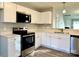 Modern kitchen featuring stainless steel appliances, white cabinets, and quartz countertops at 7702 Brisbane Ct, Charlotte, NC 28215