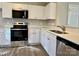 Modern kitchen featuring stainless steel appliances, white cabinets, and quartz countertops at 7702 Brisbane Ct, Charlotte, NC 28215