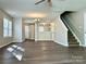 Open-concept living room featuring hardwood floors and staircase at 7702 Brisbane Ct, Charlotte, NC 28215