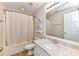 Bright bathroom with marble counter, white vanity, shower/tub, and open storage shelves at 7713 Dunoon Ln, Charlotte, NC 28269
