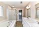 Bright bathroom featuring a bathtub, shower, vanity with marble countertop and neutral paint at 7713 Dunoon Ln, Charlotte, NC 28269