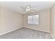 Cozy bedroom featuring neutral walls, carpet, a ceiling fan and a bright window at 7713 Dunoon Ln, Charlotte, NC 28269