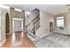 Inviting foyer with hardwood floors, staircase, and natural light from the large front door at 7713 Dunoon Ln, Charlotte, NC 28269