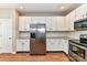 Modern kitchen with white cabinets, stainless steel refrigerator, and granite countertops at 7713 Dunoon Ln, Charlotte, NC 28269