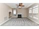Spacious living room featuring a fireplace, built-in shelving, a ceiling fan and large windows at 7713 Dunoon Ln, Charlotte, NC 28269