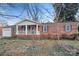 Charming brick home featuring a covered porch and well-maintained front yard at 821 Cabaniss Dr, Shelby, NC 28150