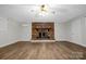 Large living room with brick fireplace, neutral paint, white trim and wood floors at 821 Cabaniss Dr, Shelby, NC 28150