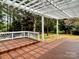 Backyard deck with a pergola and view of the trees and lawn at 8812 Glenover Cir, Charlotte, NC 28269