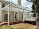 Home's backyard featuring a large deck with white pergola and mature trees at 8812 Glenover Cir, Charlotte, NC 28269