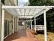Home's backyard featuring a large deck with white pergola and mature trees at 8812 Glenover Cir, Charlotte, NC 28269