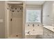 Bright bathroom featuring a glass shower stall, garden tub and vanity at 8812 Glenover Cir, Charlotte, NC 28269