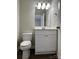 Bathroom with white toilet, vanity, mirror, light fixture, grey walls, and dark hardwood floors at 8812 Glenover Cir, Charlotte, NC 28269