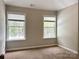 Bedroom featuring two windows providing ample natural light and carpeted flooring at 8812 Glenover Cir, Charlotte, NC 28269