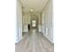 Hallway with hardwood floors, grey walls, white trim, wainscoting, and an arched doorway leading to another room at 8812 Glenover Cir, Charlotte, NC 28269