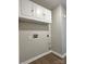 Laundry room with hardwood floors, grey walls, overhead cabinets, and electrical and plumbing hookups at 8812 Glenover Cir, Charlotte, NC 28269