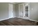 Room featuring hardwood floors, grey walls, standard door, and glass panel doors into another room at 8812 Glenover Cir, Charlotte, NC 28269
