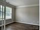 Room with hardwood floors, grey walls, crown molding, and large window with blinds at 8812 Glenover Cir, Charlotte, NC 28269