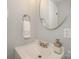 Powder room with a modern, round mirror, sleek sink and stylish fixtures at 921 Ambassador St # 1, Charlotte, NC 28208