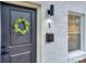 Close up of the front door, showing wreath, black fixtures, and white brick at 921 Ambassador St # 1, Charlotte, NC 28208