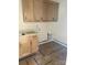 Laundry room with light wood cabinets, sink, and unfinished walls at 0 6Th Nw St, Hickory, NC 28601