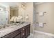 Bright bathroom with double vanity, granite counters, and tiled shower with glass door at 104 Bryant St, Belmont, NC 28012