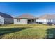 Green backyard with a well-maintained lawn, and a covered patio, offering a serene outdoor living space at 106 Chase Water Dr, Mooresville, NC 28117