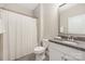A functional bathroom featuring a toilet, a shower with a curtain, and a granite countertop vanity at 106 Chase Water Dr, Mooresville, NC 28117
