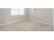 Vacant bedroom features carpet flooring, three round wall mirrors, and a window at 106 Chase Water Dr, Mooresville, NC 28117