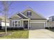 Charming one-story home with stone accents, manicured lawn, and attached two car garage at 106 Chase Water Dr, Mooresville, NC 28117